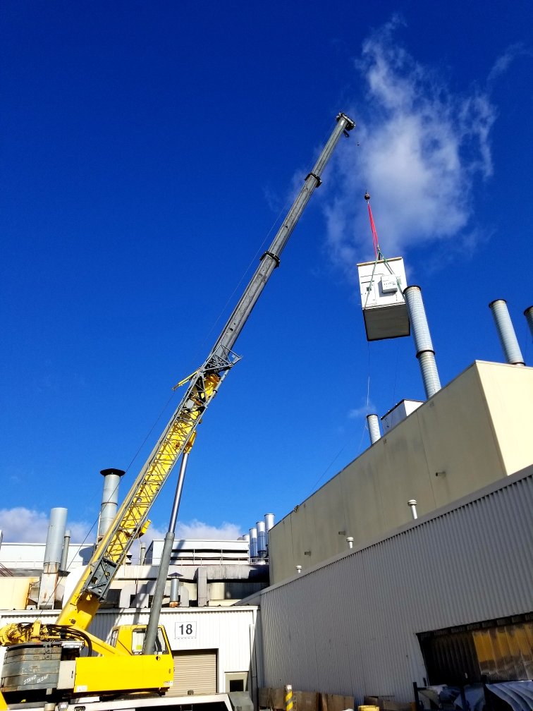 Rooftop AC unit installation with crane